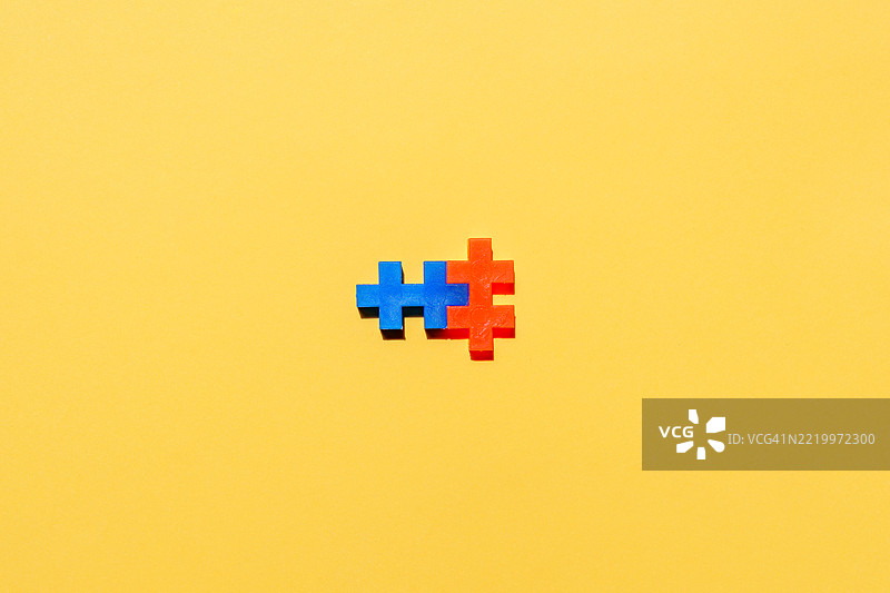 互锁的积木在黄色背景上形成一个十字形图片素材