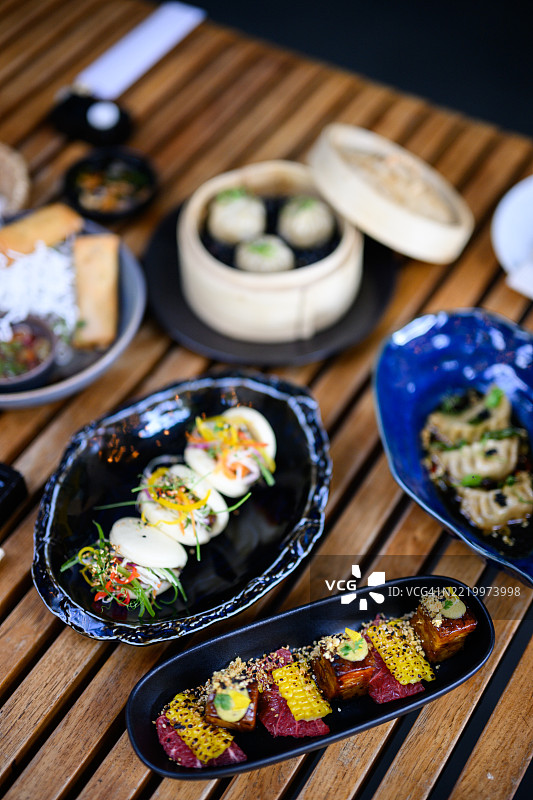 高角度拍摄的木桌，上面摆放着各种亚洲开胃菜图片素材