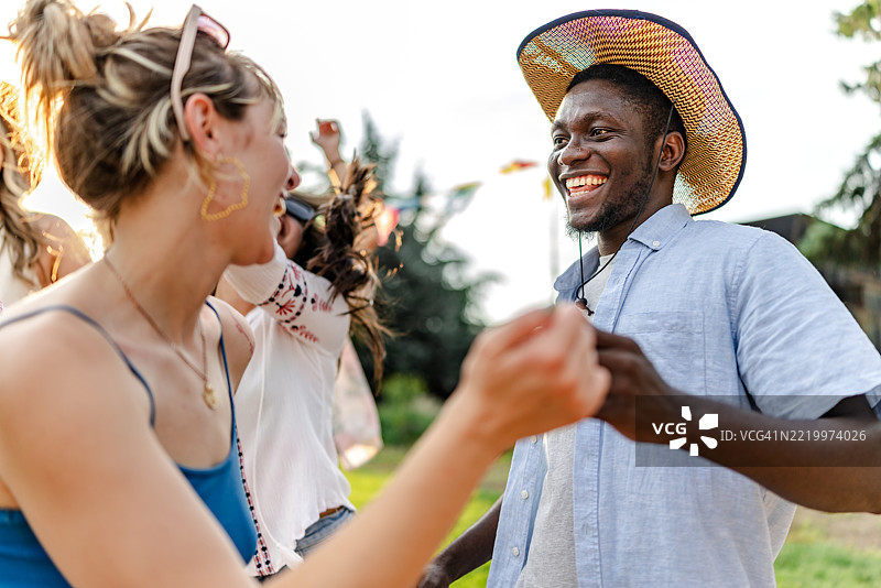 年轻人在温暖的夕阳余晖下共同庆祝充满活力的音乐节图片素材