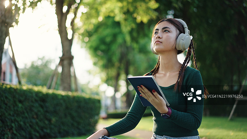 青少年在公园里写下创意笔记。图片素材