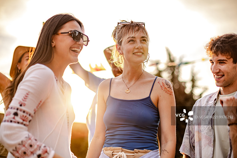 年轻人在日落时分享受充满活力的户外音乐节的兴奋感图片素材