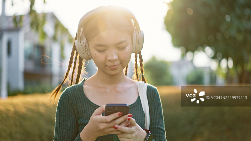 青少年在走路时使用人工智能助手。图片素材