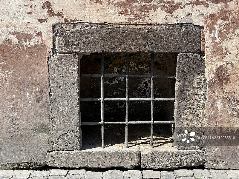 混凝土外墙上的地面方形窗户，带有铁栏杆图片素材