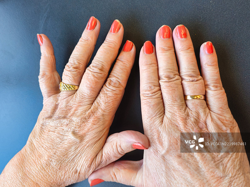女性手部的美甲，涂有橙色指甲油。图片素材