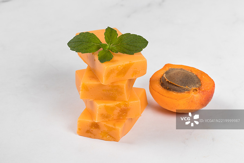 素食甜点。杏干糖果牛轧糖，里面有干杏的碎片。白色背景。特写。图片素材