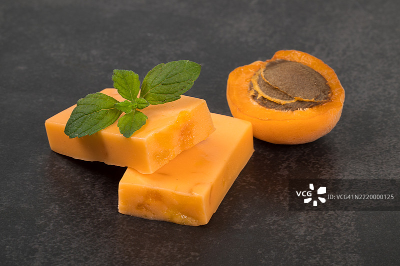 素食甜点。杏干糖果牛轧糖，配有干杏的碎片。深色背景。特写镜头。图片素材