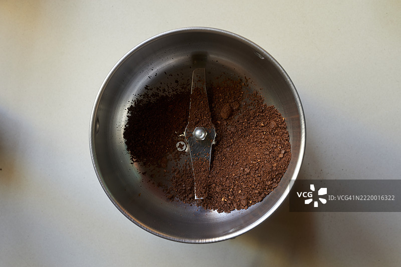 新鲜研磨的咖啡豆在手动磨豆机中图片素材