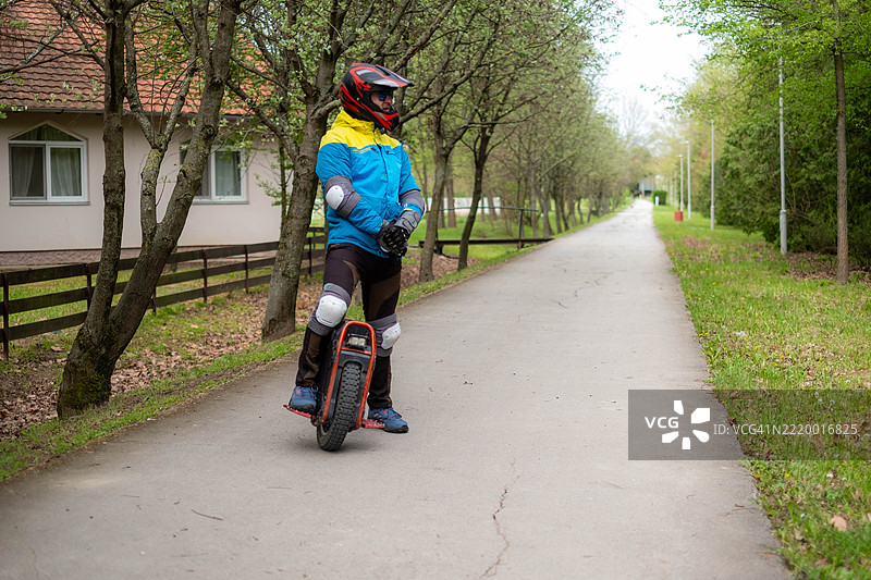 一名穿着保护装备的男子在公园骑独轮车图片素材