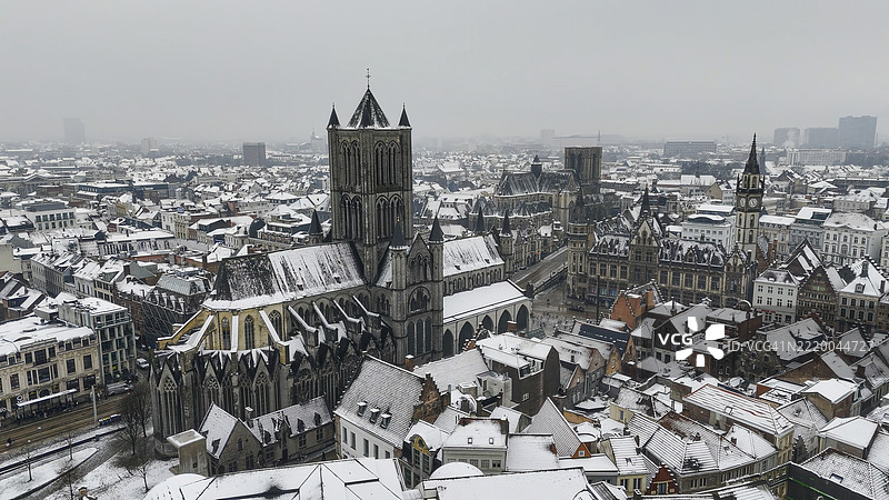 比利时根特冬季的老邮局、圣尼古拉斯教堂、钟楼和圣巴夫大教堂的鸟瞰图，雪覆盖的屋顶，哥特式建筑和历史城市景观概念图片素材
