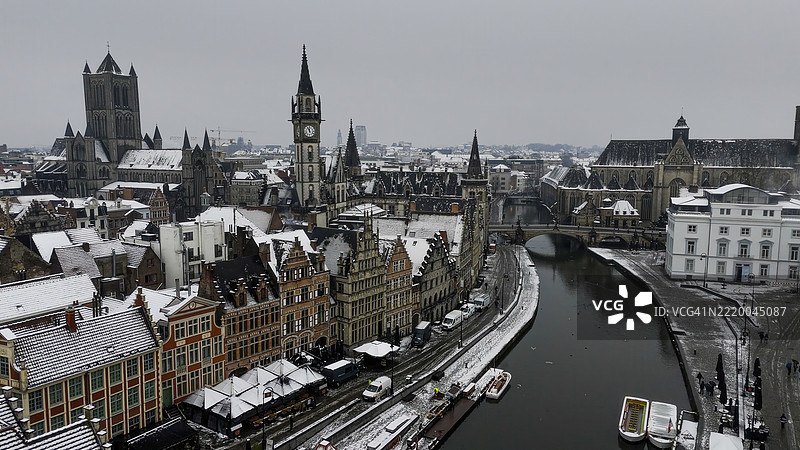 比利时根特冬季的老邮局、圣尼古拉斯教堂、钟楼和圣巴夫大教堂的鸟瞰图，雪覆盖的屋顶，哥特式建筑和历史城市景观概念图片素材