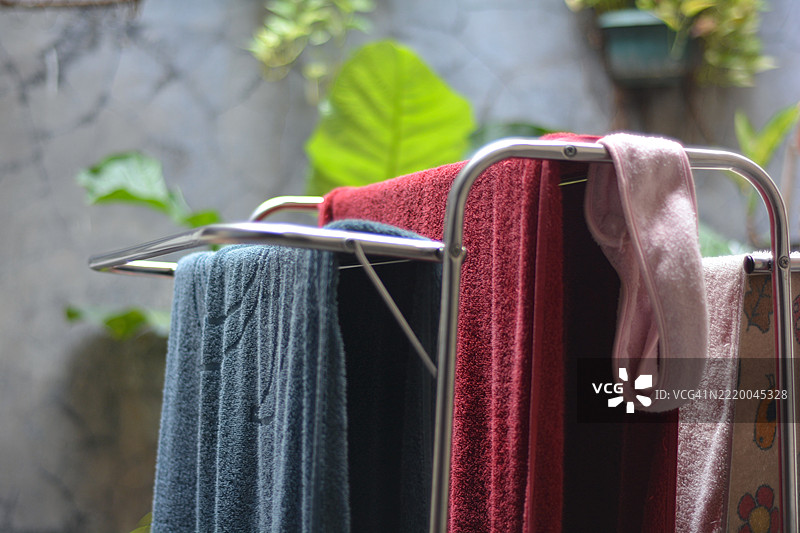 五颜六色的毛巾挂在晾衣架上晒干图片素材