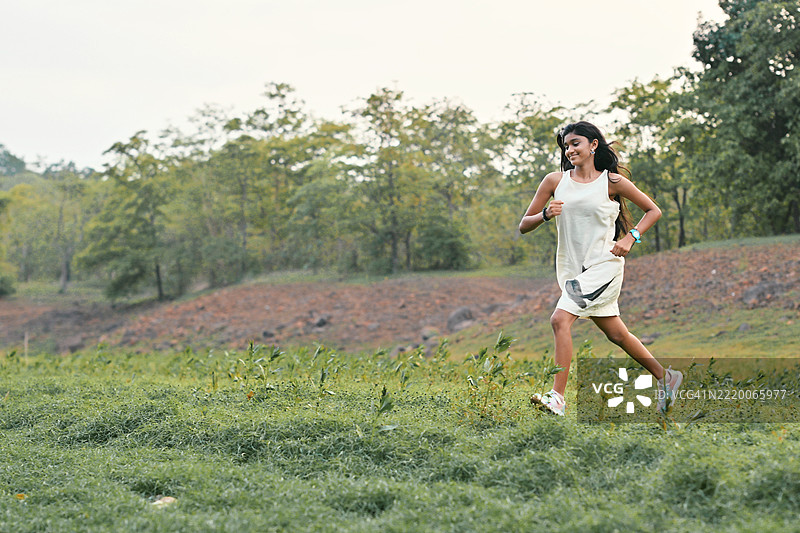 快乐的青春期女孩在大自然中自由奔跑图片素材