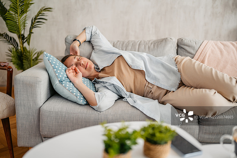 年轻女性在家中沙发上睡觉图片素材