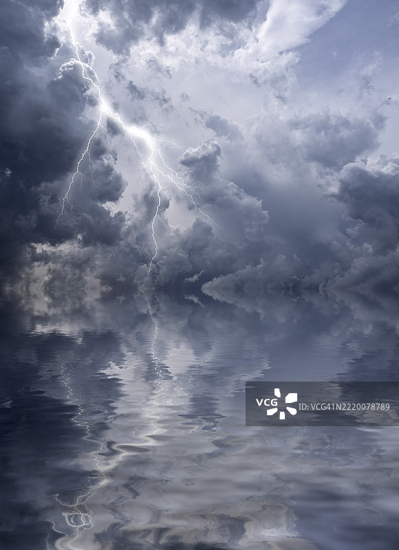 暴风云和闪电映照在水面上的天空。图片素材