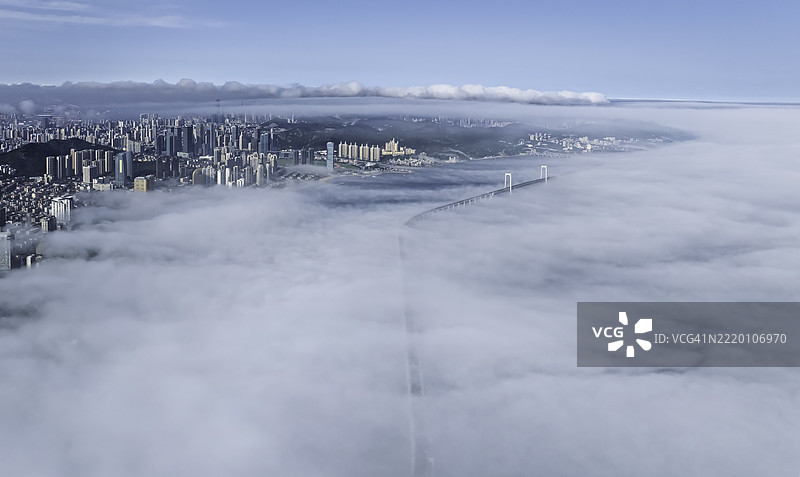 海岸雾霭中的城市天际线和海桥的鸟瞰图图片素材