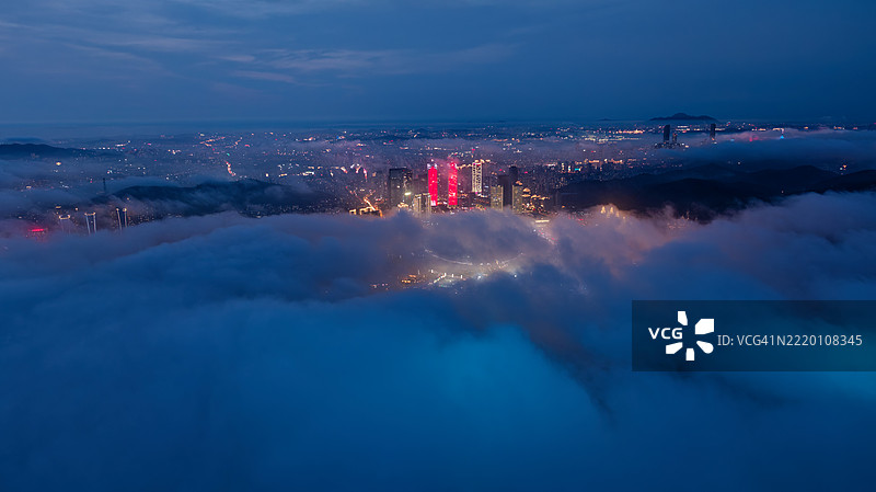 夜间城市天际线在雾中显现的鸟瞰图图片素材