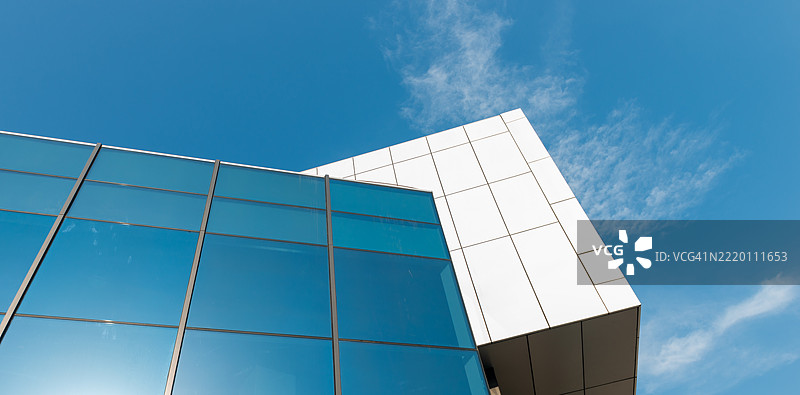 现代玻璃建筑，蓝天倒影，几何建筑设计，用于城市设计图片素材