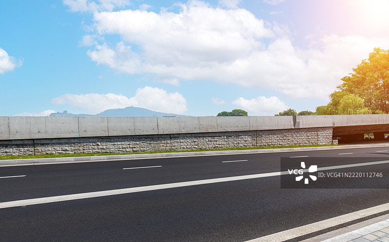 空旷的高速公路与混凝土隔离栏在晴朗的蓝天下图片素材