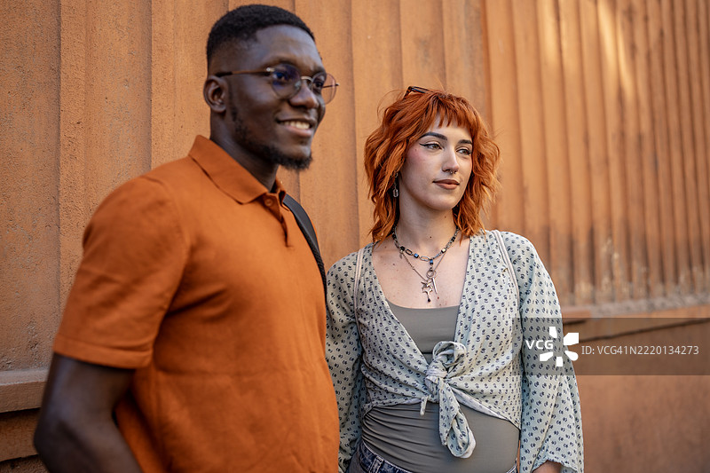 阳光明媚的日子里，朋友们在城市背景下微笑嬉戏图片素材