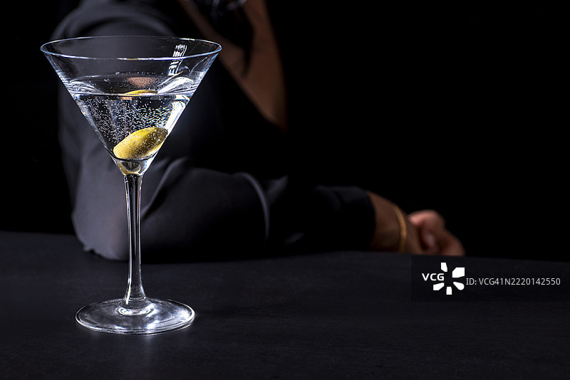 一位女性在酒吧喝马提尼。图片素材
