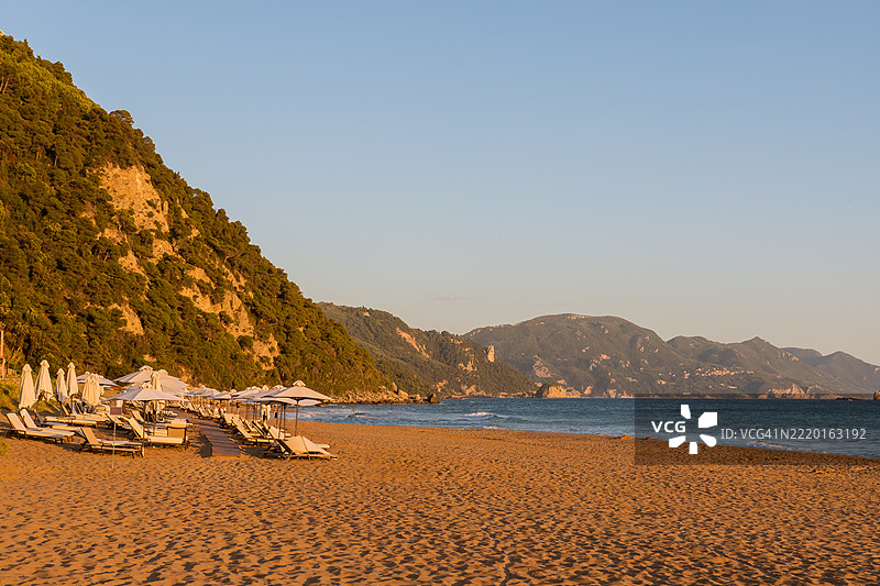 希腊科孚岛的格利法达海滩在金色时刻，阳光照耀着山脉。图片素材