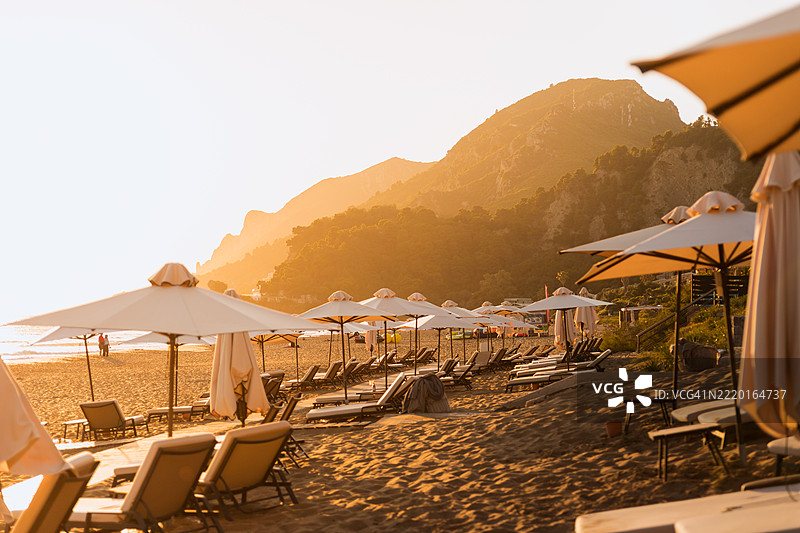 希腊科孚岛的格利法达海滩在金色时刻，阳光照耀着山脉。图片素材