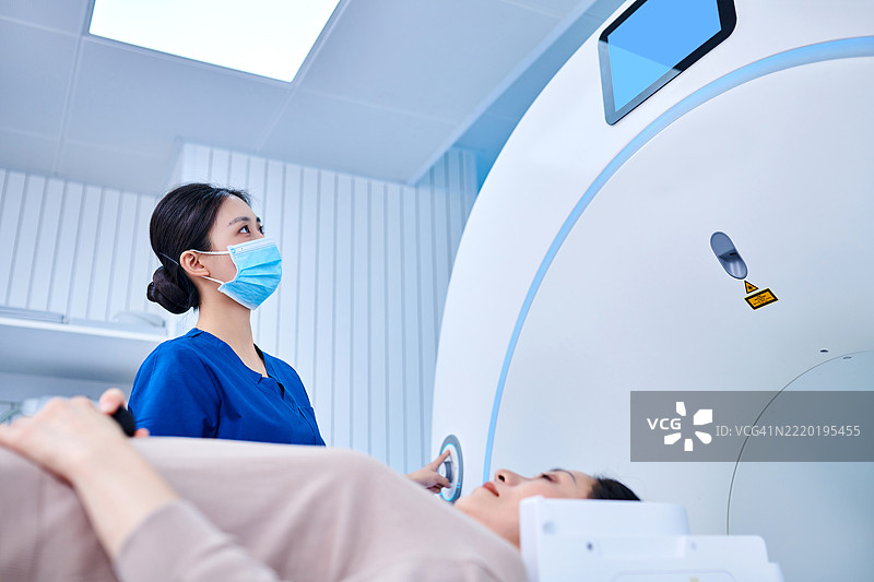 女性护士在MRI扫描室操作MRI扫描仪图片素材