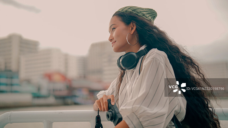 年轻的亚洲女性在泰国独自旅行时，欣赏曼谷河边的美景。图片素材