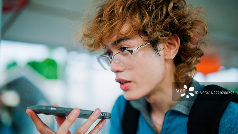 年轻的亚洲男子在泰国旅行时使用人工智能将他的语言翻译成泰语。图片素材