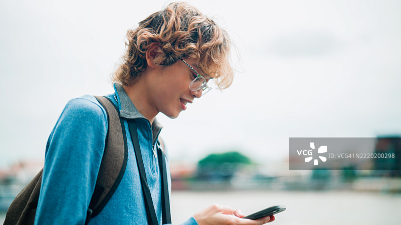年轻的亚洲男子在泰国旅行时使用人工智能将他的语言翻译成泰语。图片素材