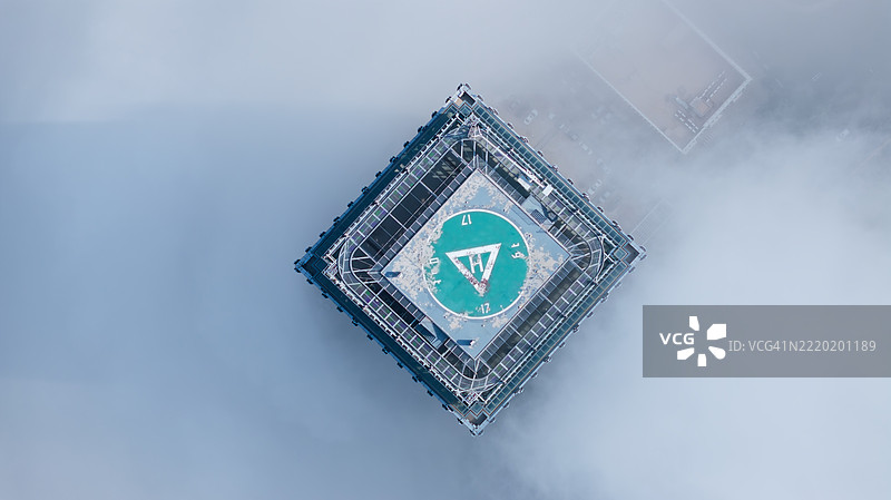 从上方俯视大连，中国，一座摩天大楼穿越云层。图片素材