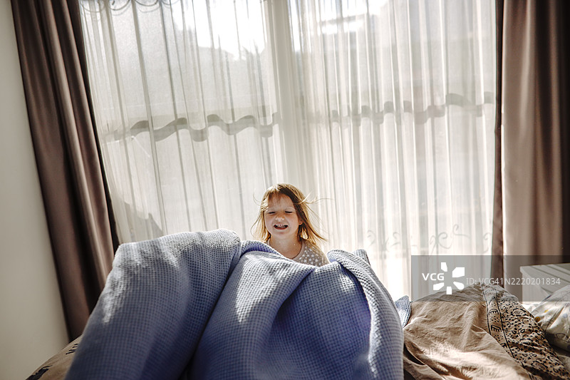 早晨的温暖与柔情：孩子独立整理自己的床铺图片素材