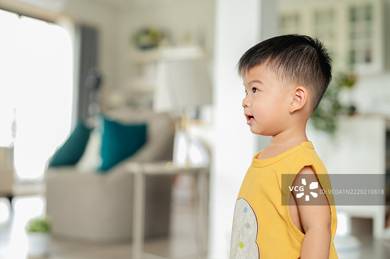 亚洲男婴，年龄在12到23个月之间，在明亮的厨房里用彩色马克笔在纸上画画，享受创作的乐趣。专注而顽皮，宝宝在温馨的家中探索创造力和自我表达，创作有趣的涂鸦。图片素材