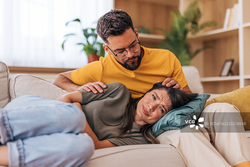 男人在家中安慰躺在沙发上的伤心女友图片素材