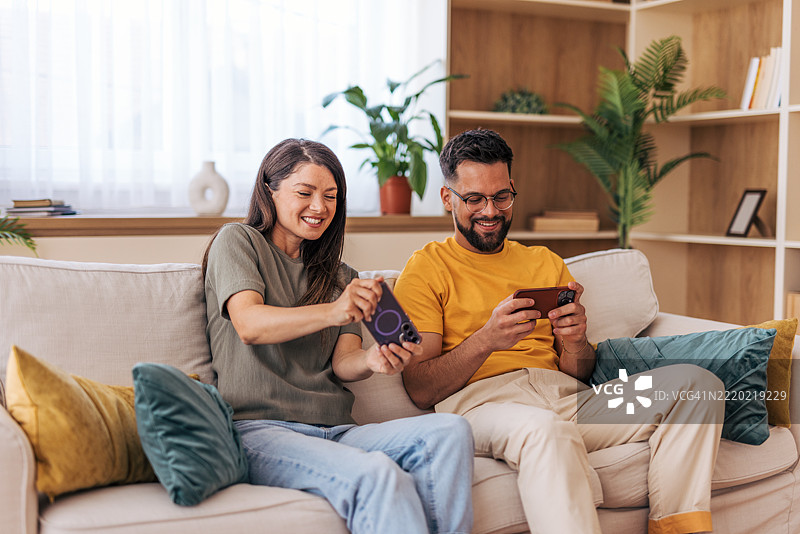 情侣在家里玩手机游戏图片素材