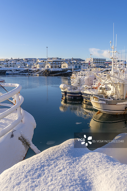 冬季哈夫纳夫约尔港口的船只和背景小镇景观，哈夫纳夫约尔，冰岛图片素材