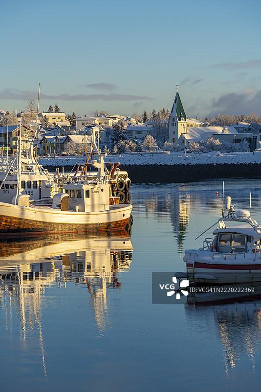 冬季哈夫纳夫约尔港口的船只和背景小镇景观，哈夫纳夫约尔，冰岛图片素材