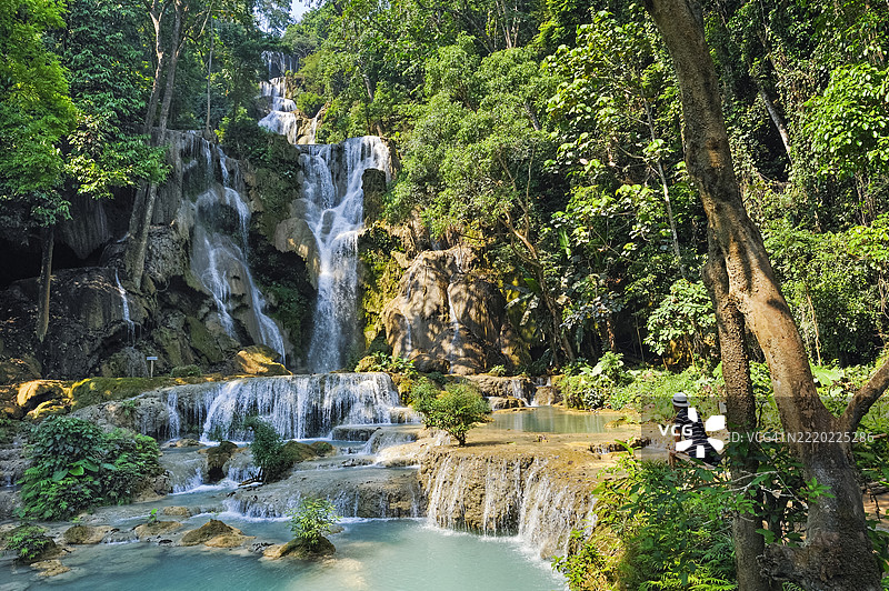 男子欣赏老挝琅勃拉邦的光西瀑布图片素材
