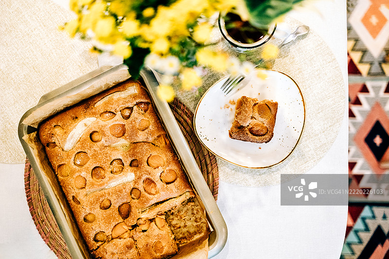 咖啡、自制杏子蛋糕和花朵营造出温馨的桌面氛围图片素材