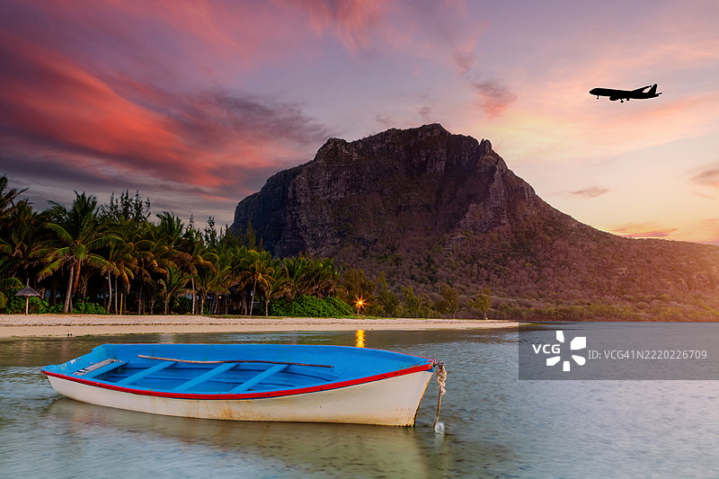 毛里求斯勒莫尔布拉班特的热带海滩日出与飞行的飞机图片素材