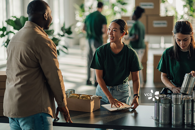 志愿者在仓库为慈善活动准备食品捐赠图片素材