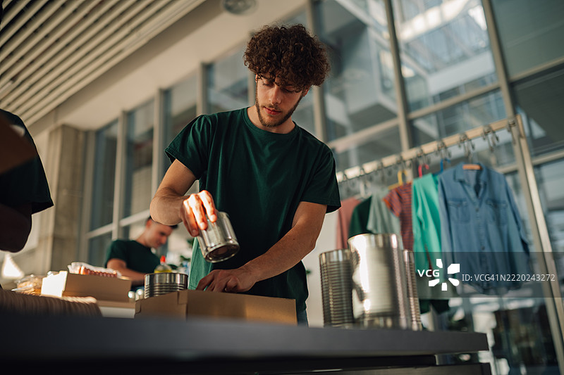 年轻男性志愿者在社区中心准备捐赠包裹图片素材