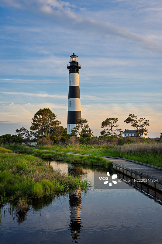 博迪岛灯塔在日落时映照在池塘中图片素材