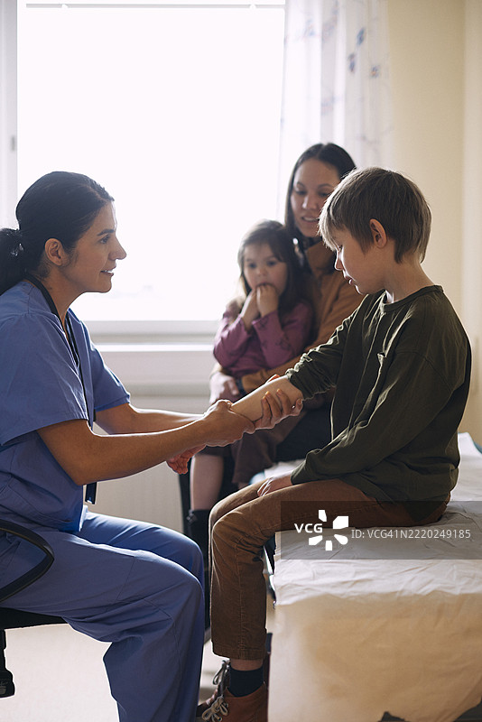 微笑的女医生在医疗诊所为患者检查图片素材