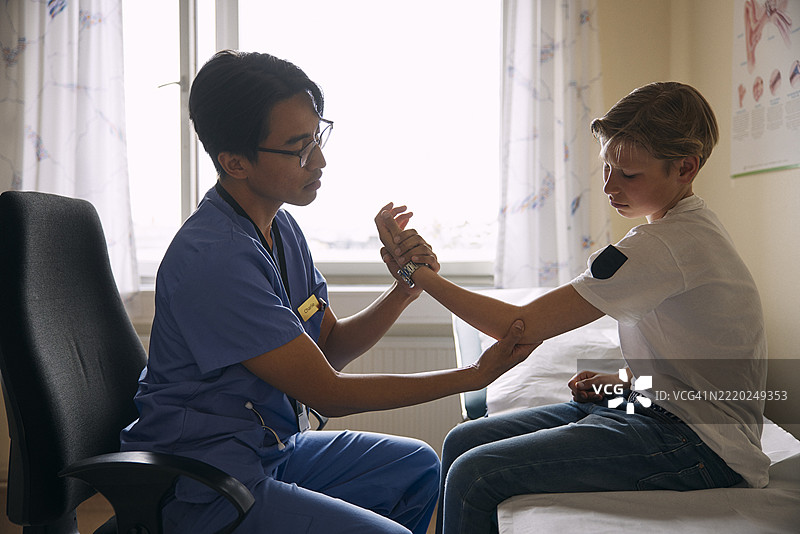 医生在医疗诊所检查病人的手臂图片素材