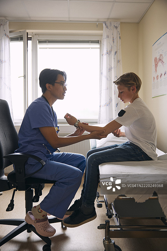 医生在诊所检查病人的手臂图片素材