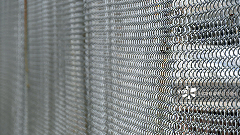 金属围栏网的特写和侧面视图。聚焦于前景。美国纽约州曼哈顿。阳光。自然色彩。全画幅16x9。图片素材