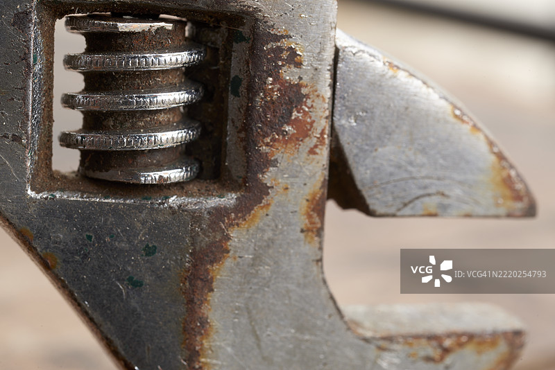 生锈的可调扳手特写，显示磨损的金属齿图片素材