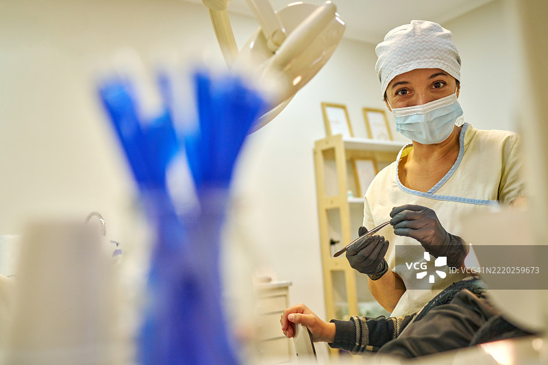 现代牙科办公室中，儿科牙医正在检查年轻患者图片素材