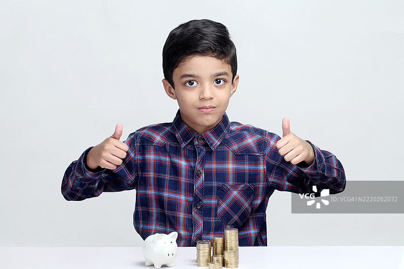 竖起大拇指的小男孩——儿童储蓄概念图片素材